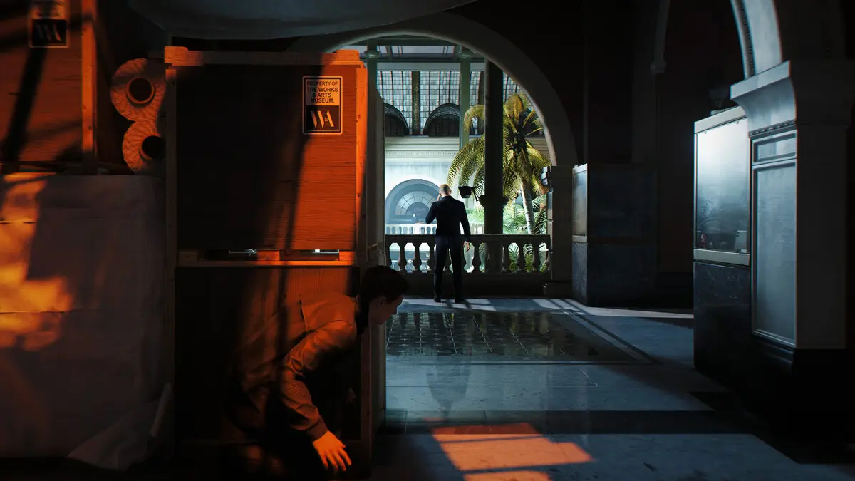 Person hiding behind exhibit in museum hallway
