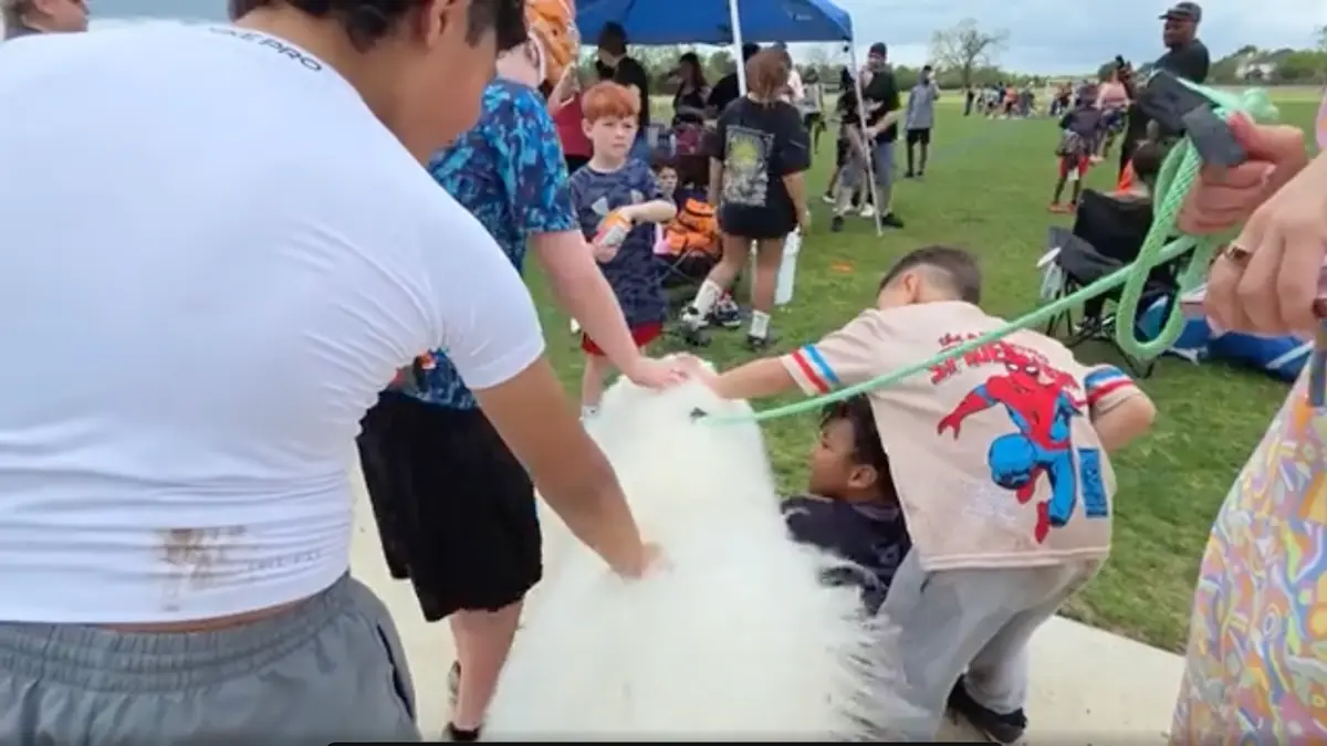 Children petting large fluffy white dog outdoors