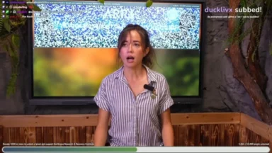 Woman livestreaming before monitor displaying QR-code-like static