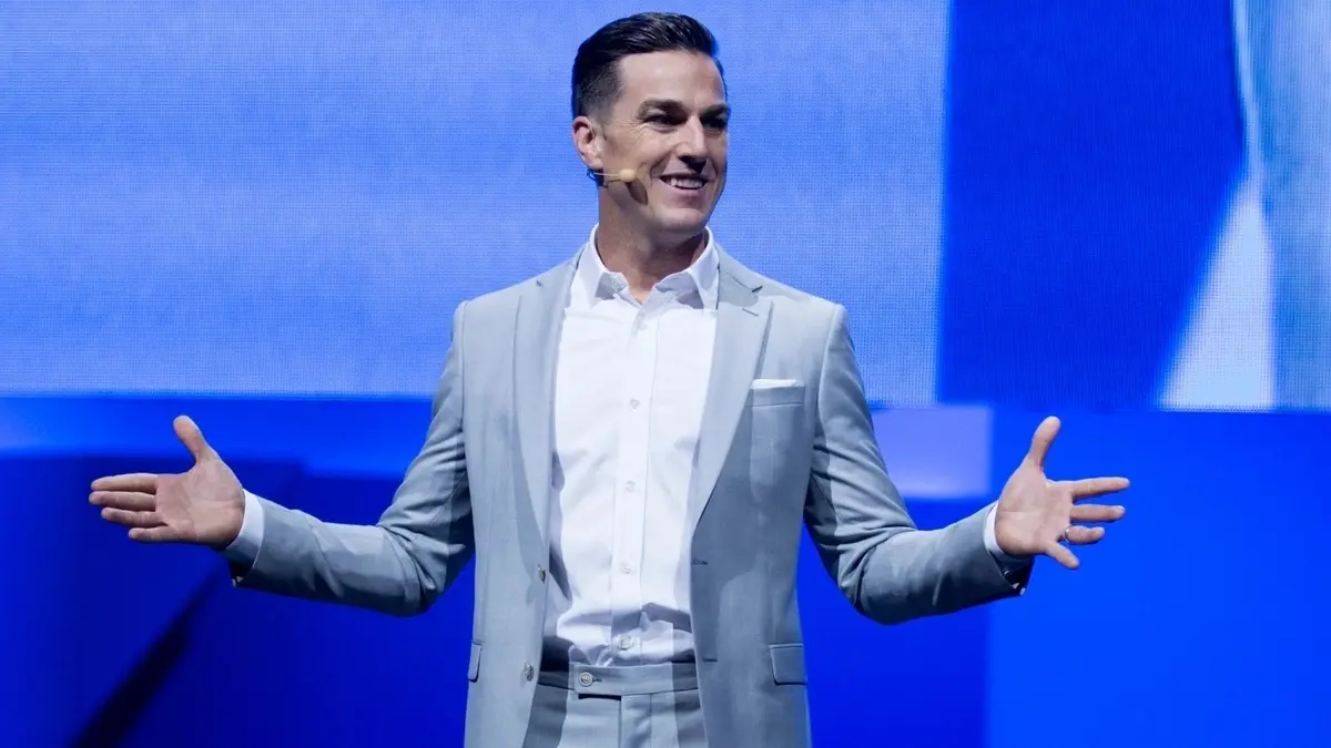 Man in gray suit speaking on stage