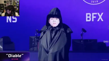 Gamer in black cloak on esports stage