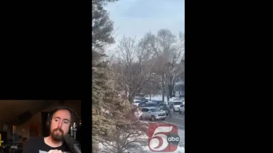 News clip showing snowy street and parked cars.
