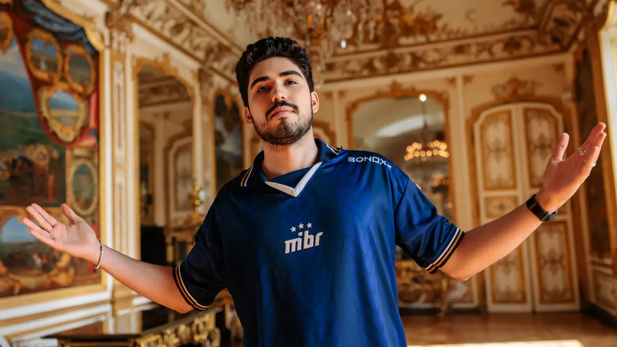 Man in blue jersey poses in ornate room