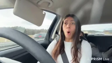 Woman driving car with surprised expression