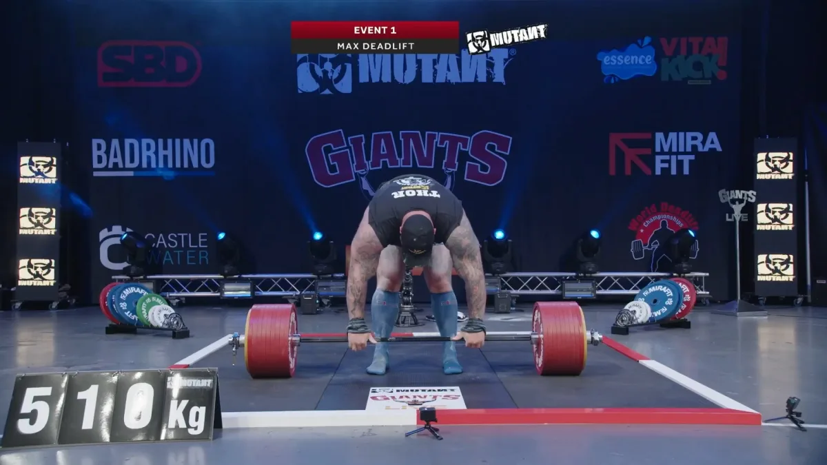 Strongman lifting 510 kg barbell in competition.