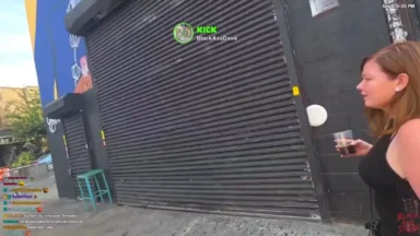 Woman holding drink outside black shuttered storefront