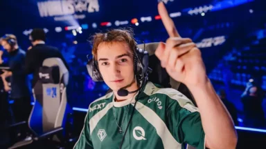 Esports player wearing headset pointing upward on stage