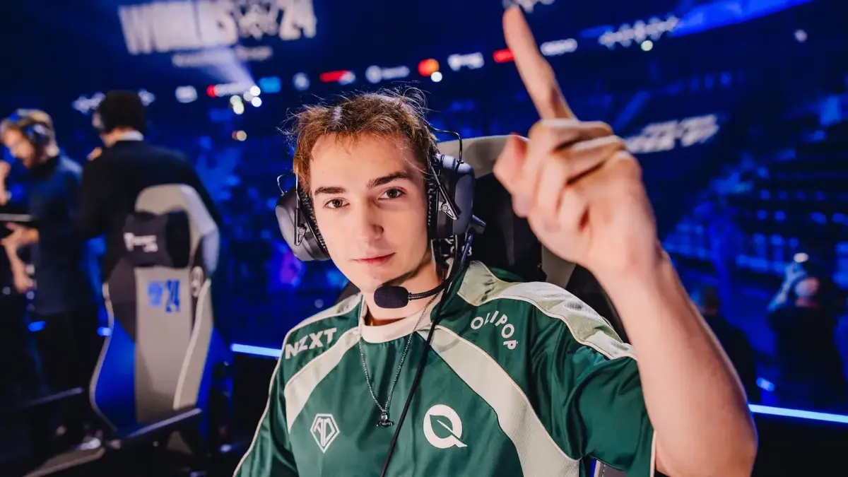 Esports player wearing headset pointing upward on stage