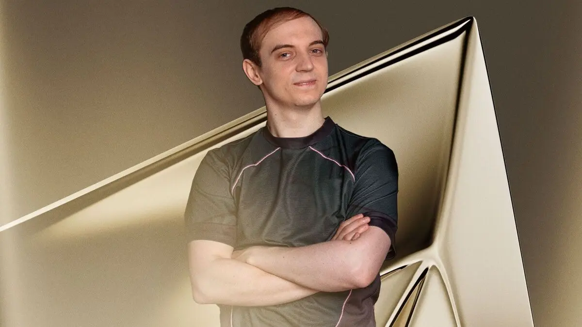 Man with folded arms before abstract metallic backdrop
