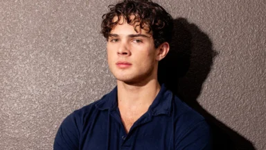 Young man in navy shirt against textured wall