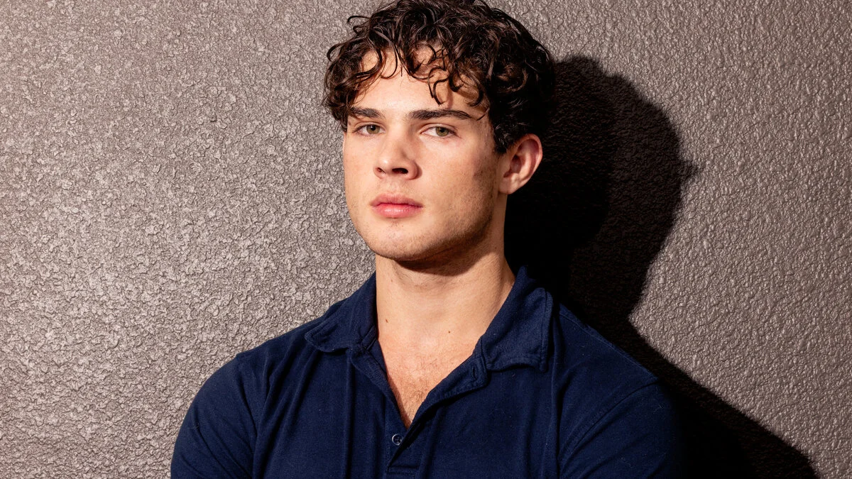 Young man in navy shirt against textured wall