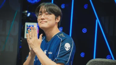 Esports player in blue jersey applauding onstage