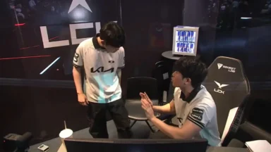 Two esports players talk in a team booth