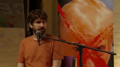 Man speaking into microphone during art event