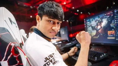Esports player celebrates beside a League of Legends monitor