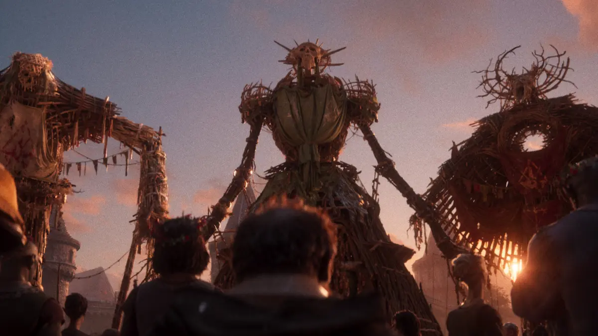 Giant straw figures towering over crowd at sunset