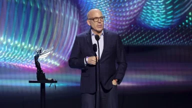 Man speaking on stage at an award show
