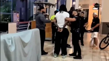 Police officers detaining man inside shopping mall