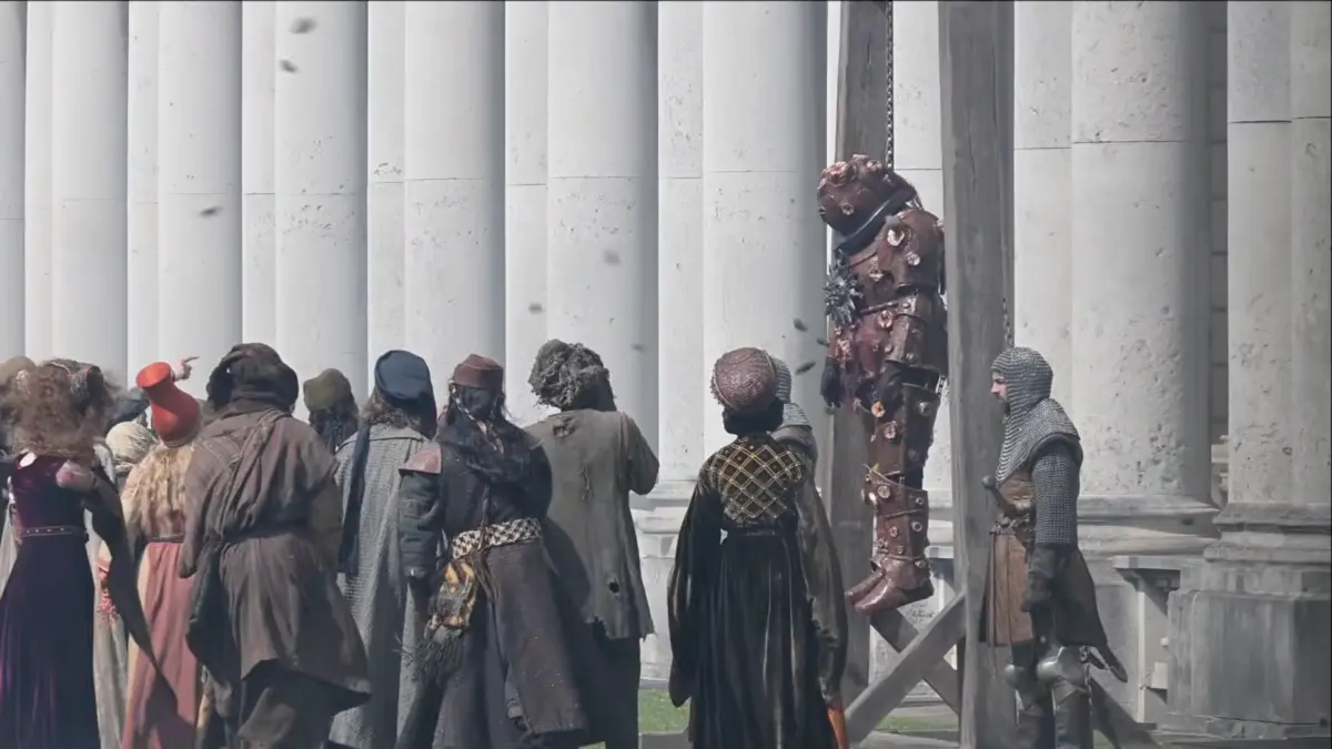 Medieval crowd watching armored figure hanging publicly