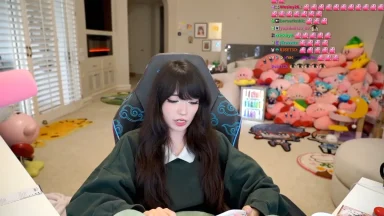 Streamer sitting in gaming chair with plush toys behind