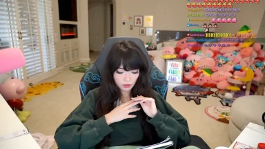 Streamer sitting in gaming chair with plush toys
