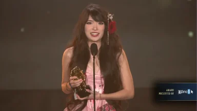 Woman holding trophy on stage during award ceremony
