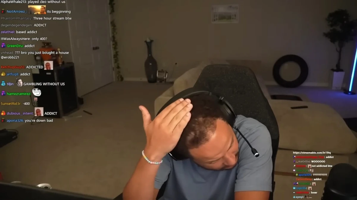 Streamer with headset holding head during live broadcast