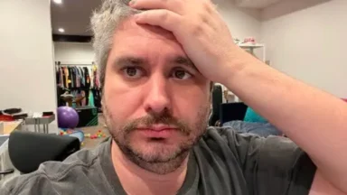 Man holds forehead with worried expression indoors