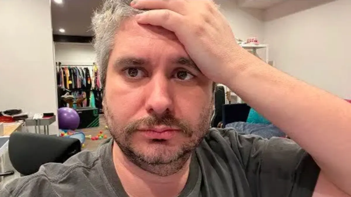 Man holds forehead with worried expression indoors