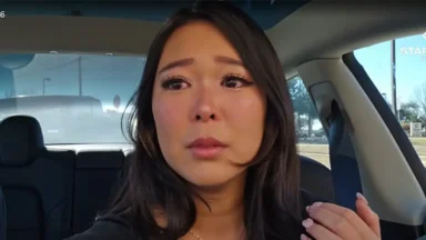 Woman sitting in car looking emotional