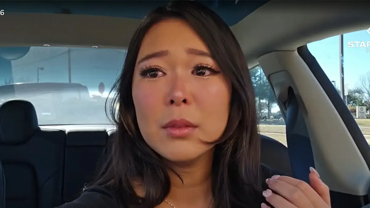 Woman sitting in car looking emotional