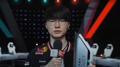Gamer holding esports trophy and microphone on stage.