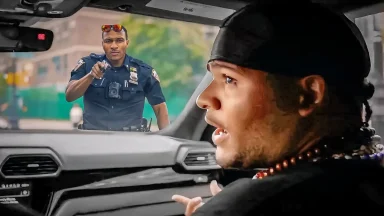 Police officer stops driver, seen from inside car.