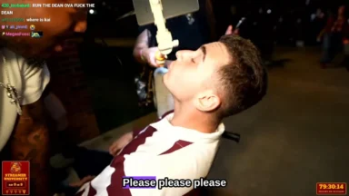 Man drinking from suspended bottle at event