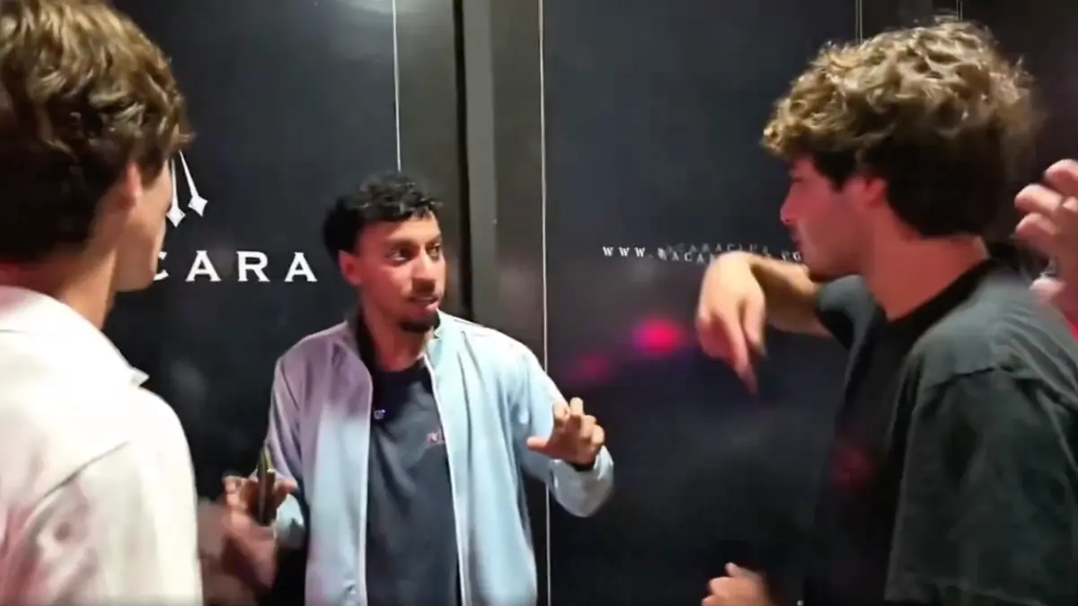 Three young men talking indoors at event