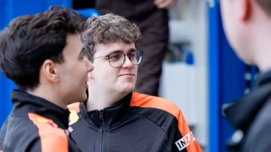 Two men in black and orange team jackets talking