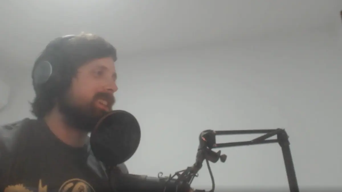 Man recording podcast with microphone and headphones