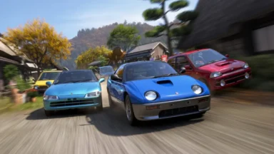 Three colorful sports cars racing through village street