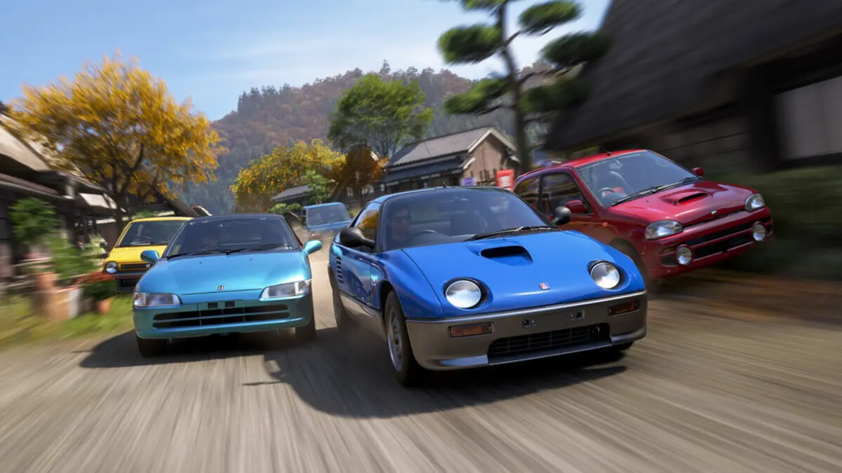 Three colorful sports cars racing through village street