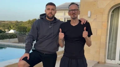 Two men posing by a poolside.