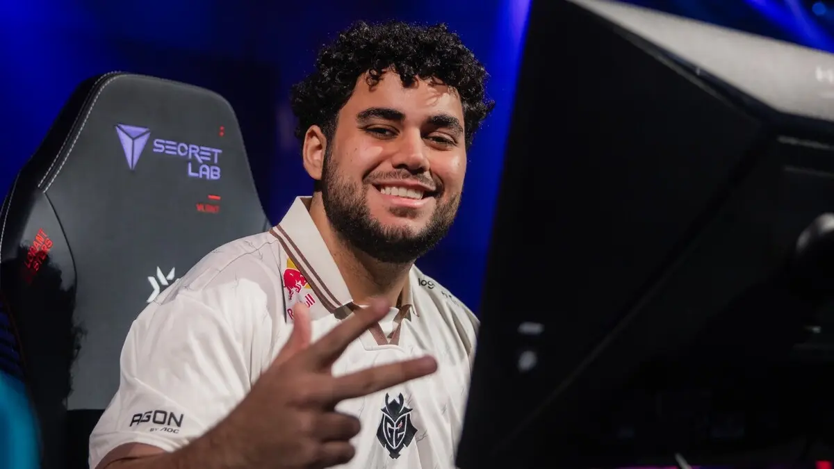 Smiling G2 Esports player flashes peace sign at computer