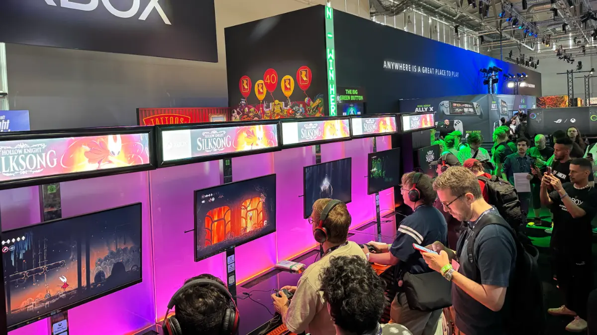 Gamers playing Hollow Knight: Silksong at gaming event.