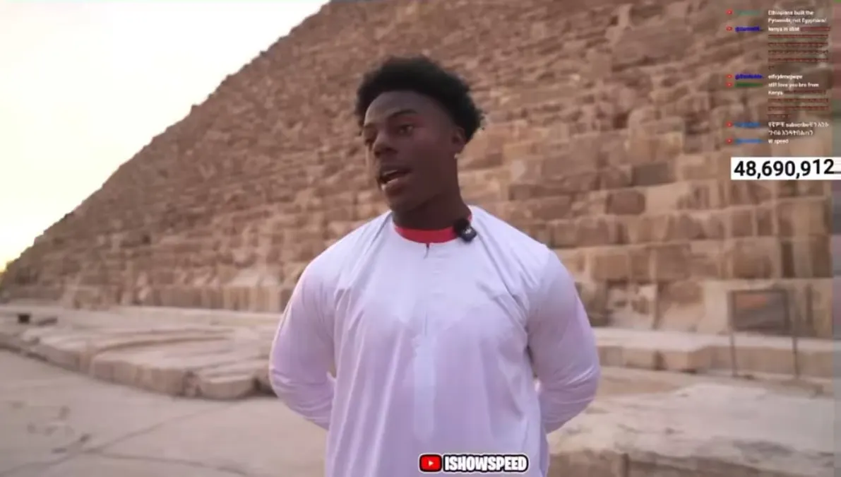 Person standing near an ancient pyramid structure.