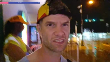 Man wearing colorful cap at night on city street