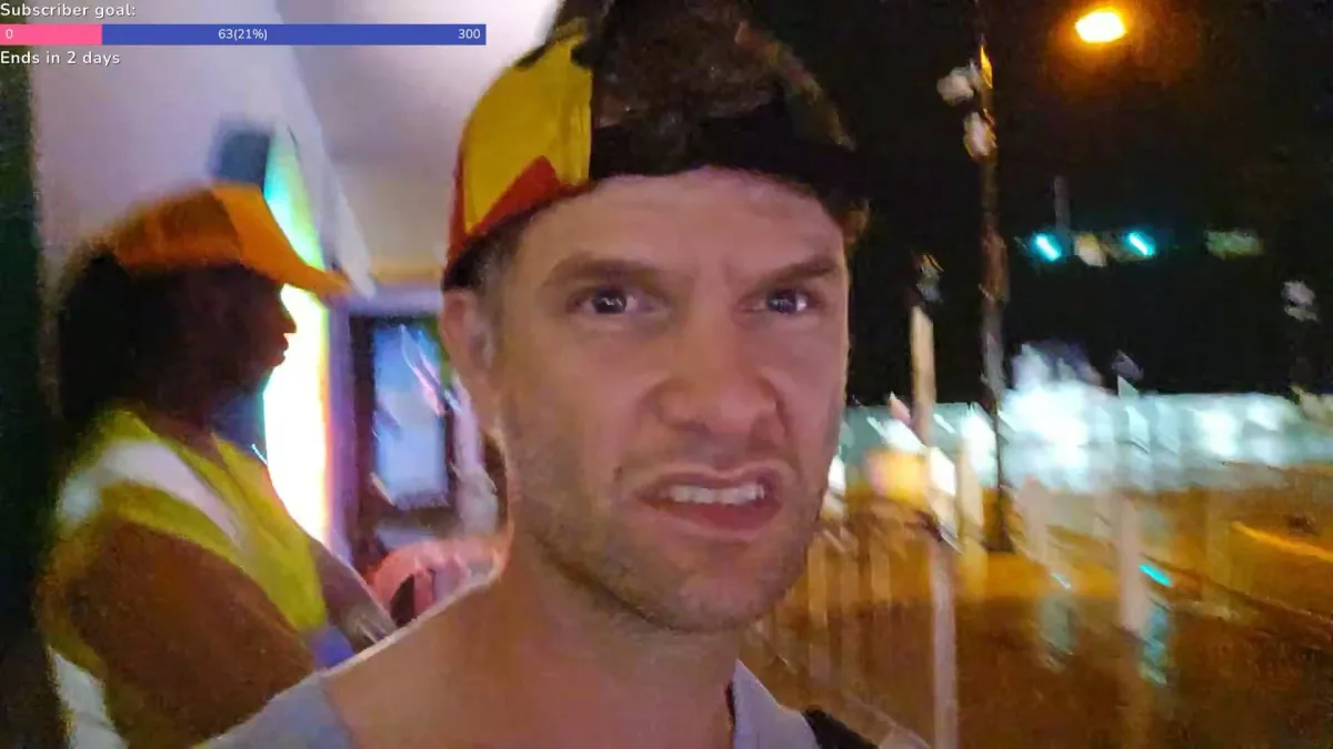 Man wearing colorful cap at night on city street