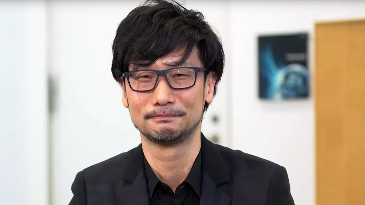 Man wearing glasses and black suit indoors