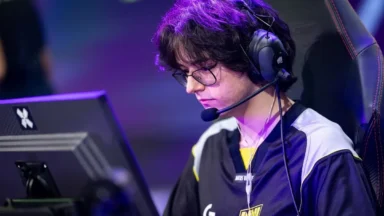 Esports player wearing headset focuses on computer monitor