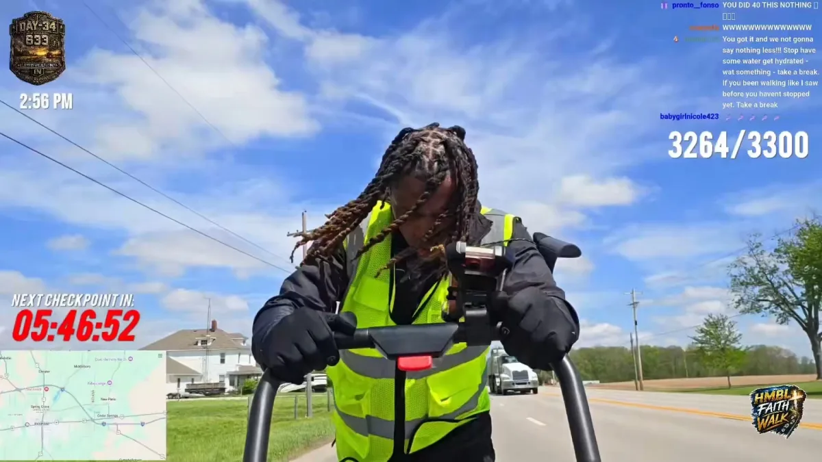 Person in reflective vest pushing stroller on roadside