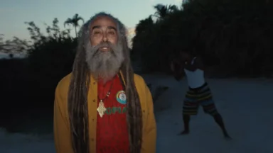 Man with long dreadlocks outdoors at dusk