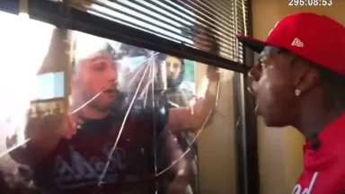 People confronting each other through broken window.